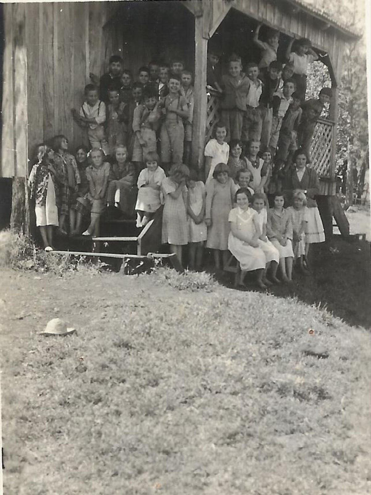 Crianças posando na escada da escola rural de madeira, 1957