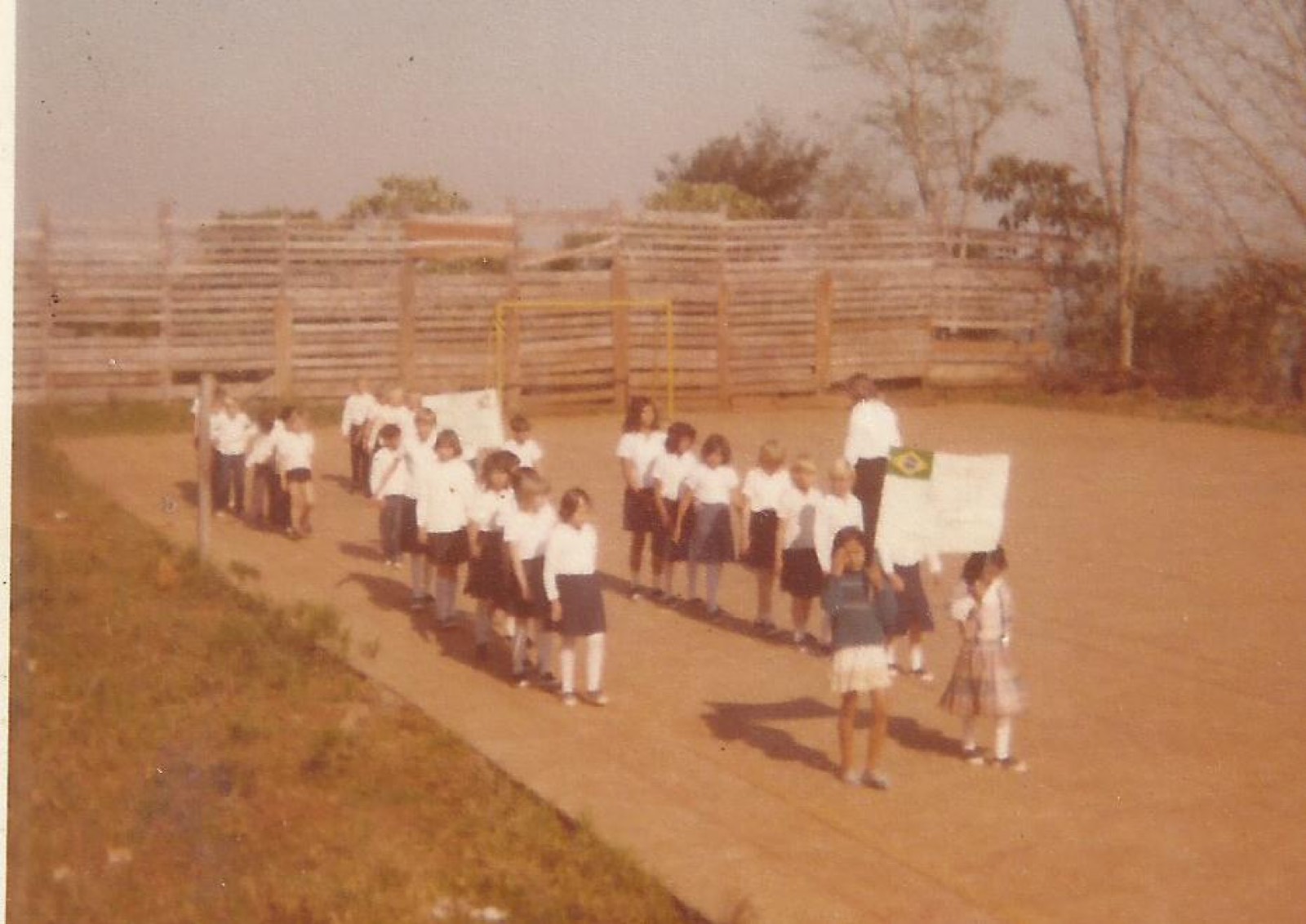 Crianças com a bandeira do Brasil em desfile cívico, anos 1980