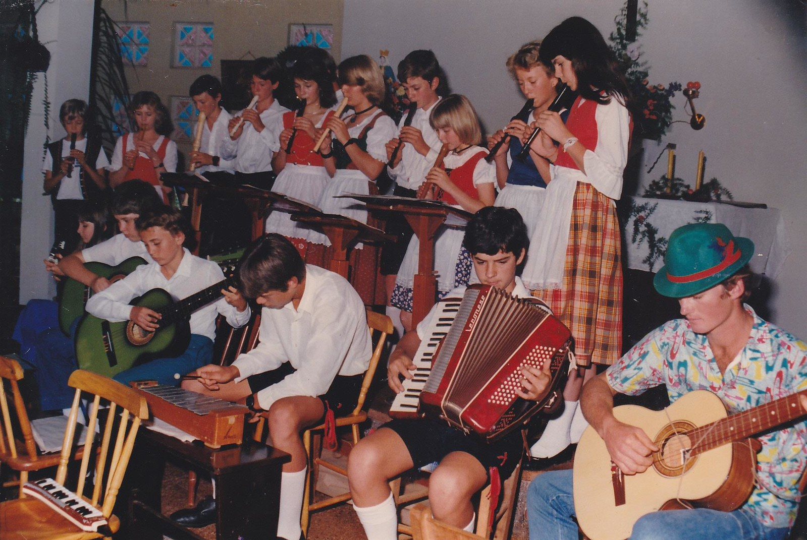 Músicos com gaita e violão acompanhando grupo de dança em trajes típicos