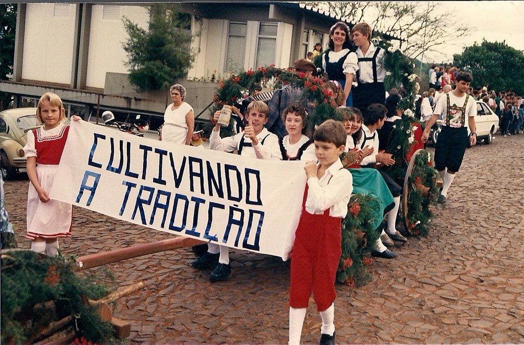 Desfile com faixa "Cultivando a Tradição" pelas ruas da cidade