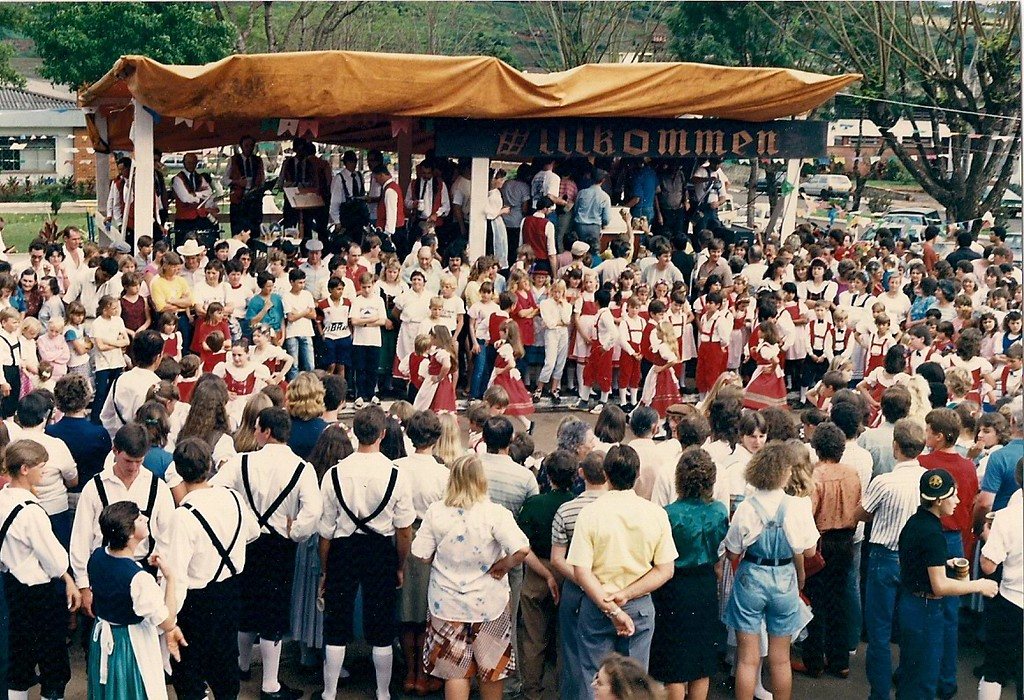 Multidão diante do palco com a faixa "Willkommen"