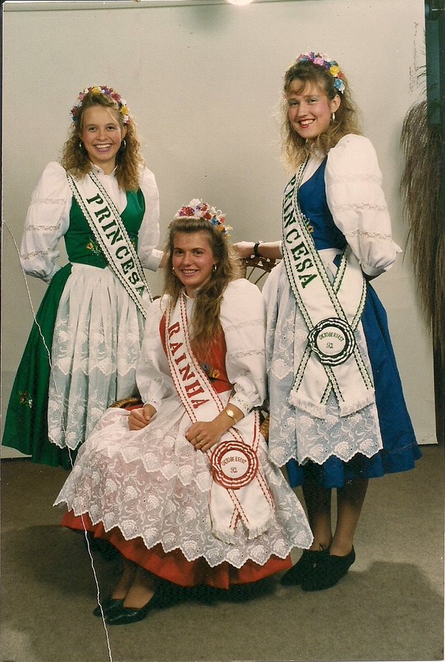 Rainha e princesas com coroas de flores e faixas