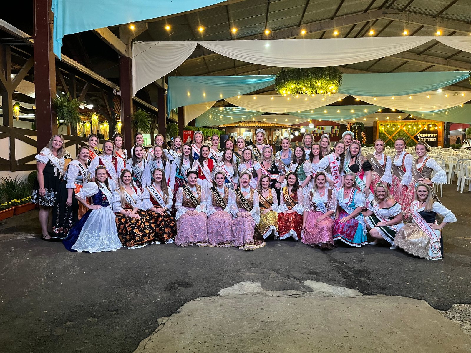 Grande grupo de dança em trajes típicos reunido no pavilhão