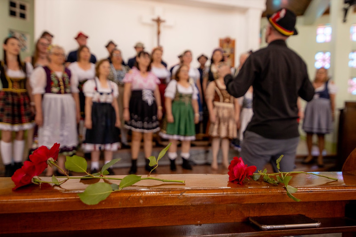 Rosas vermelhas sobre o banco da igreja, com o coral ao fundo