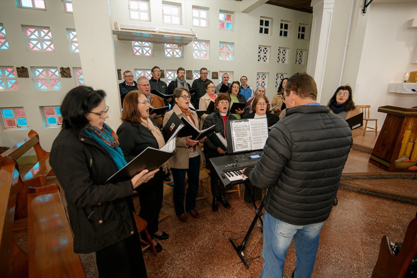 Coral cantando na igreja, sob a regência do maestro